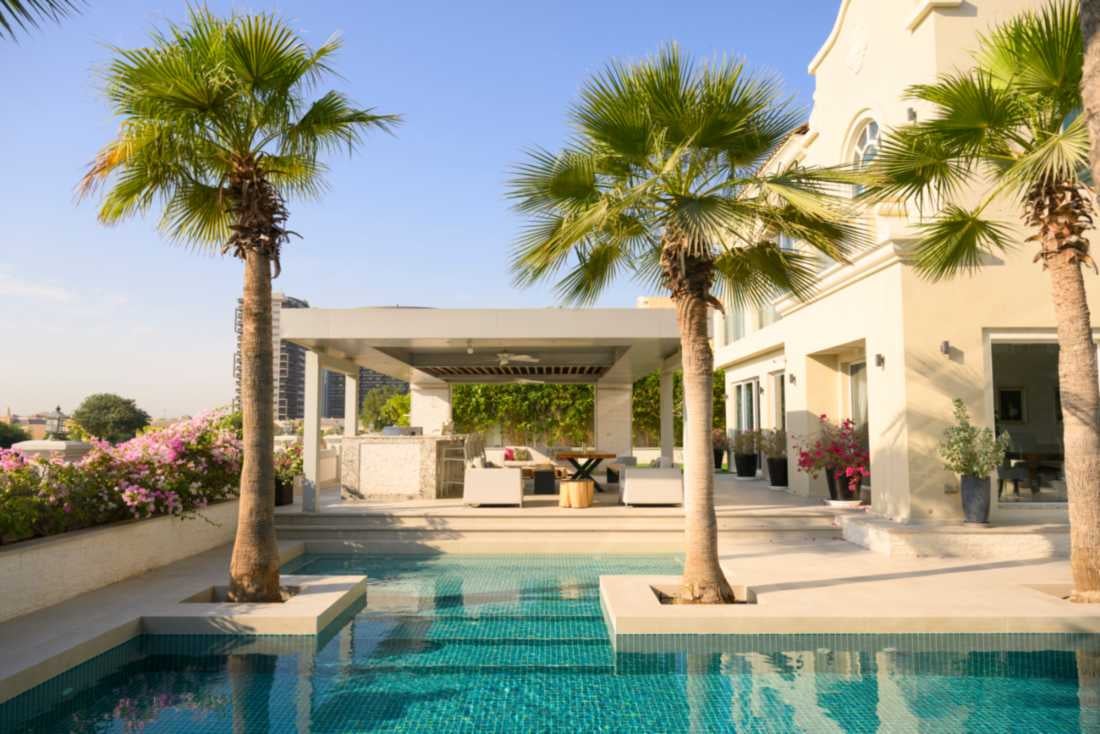 Contemporary inground pool with turquoise tiles and shaded outdoor space.